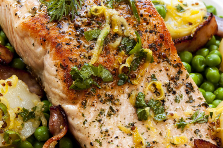 Pescatarian Lemon and Herb Grilled Salmon, Atlantic salmon, grilled with bacon, lemon zest, parsley and dill. Served with new potatoes and peas.